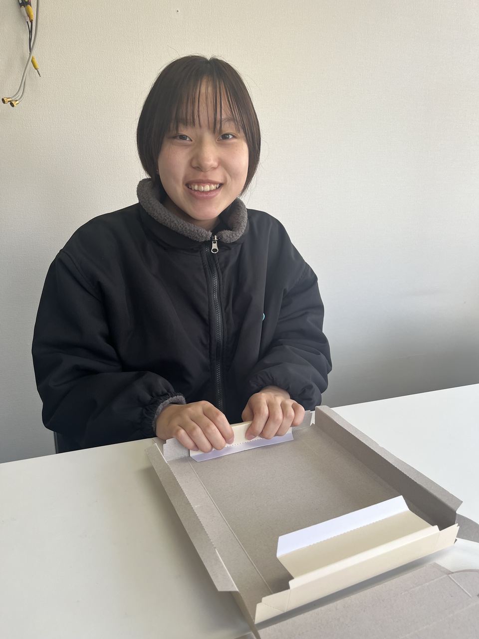 作業台で、封入の作業をしている利用者さん