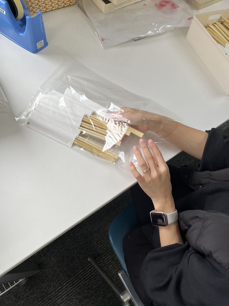 透明な袋に商品を入れて、ていねいにラッピングしている手元